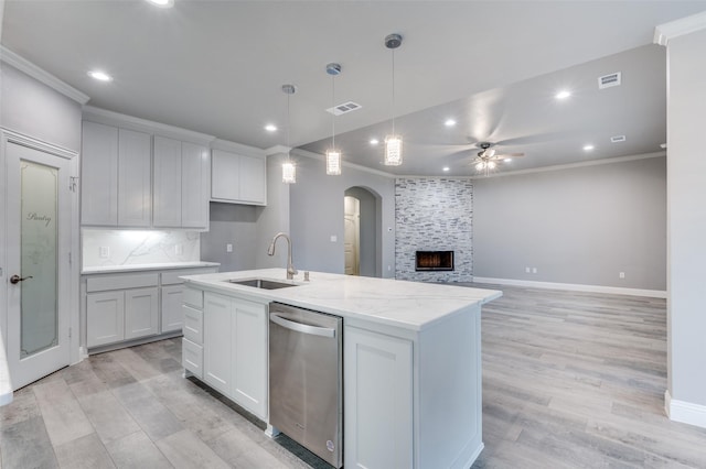 kitchen featuring white cabinetry, stainless steel dishwasher, sink, and a center island with sink