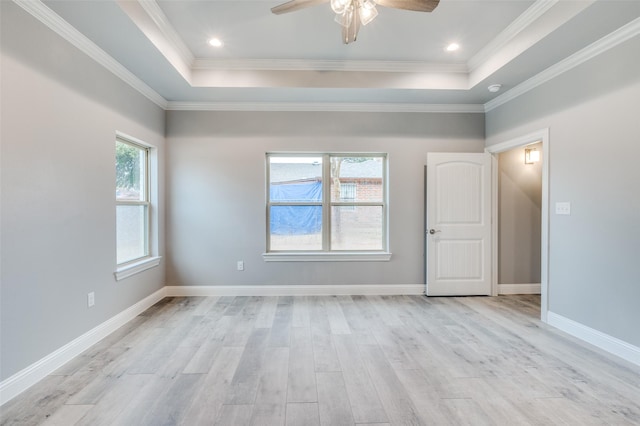 unfurnished room featuring crown molding, ceiling fan, a tray ceiling, and light wood-type flooring