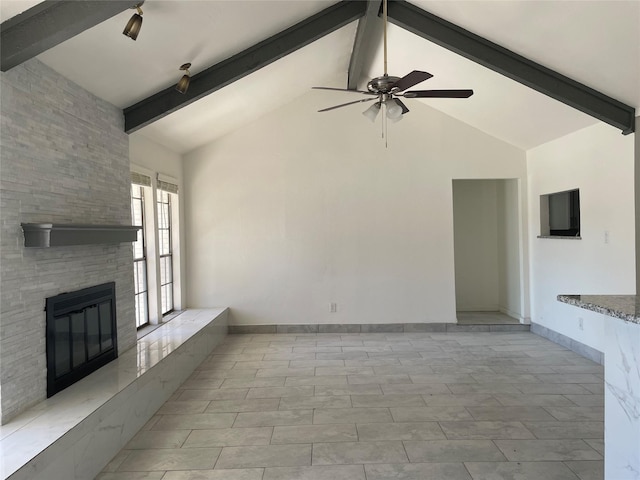 unfurnished living room with beamed ceiling, ceiling fan, high vaulted ceiling, and a fireplace