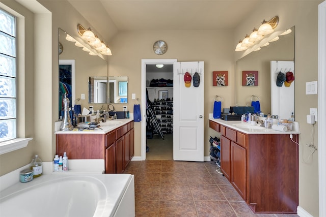 bathroom with vanity, a bath, and tile patterned flooring