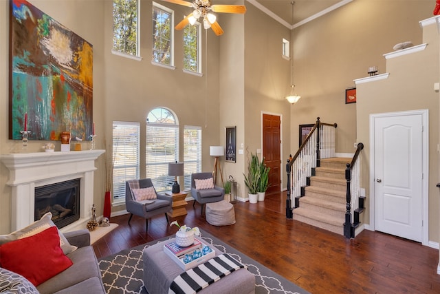 living room with crown molding, ceiling fan, and dark hardwood / wood-style flooring