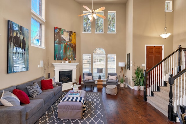 living room featuring ceiling fan and dark hardwood / wood-style floors