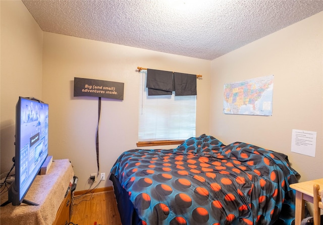 bedroom with hardwood / wood-style floors and a textured ceiling