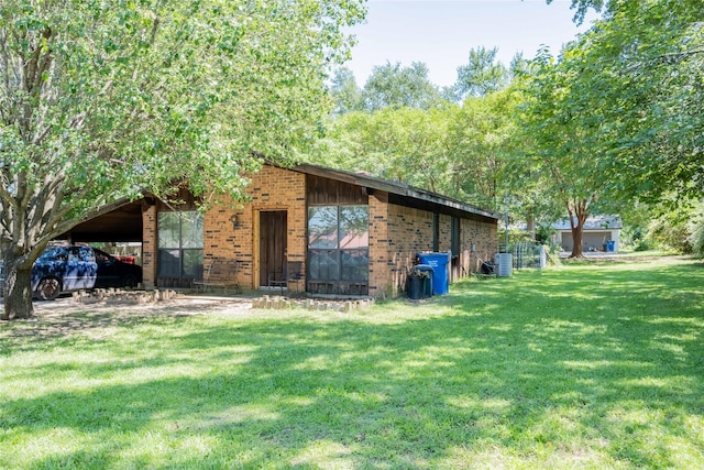 exterior space with a carport and a lawn