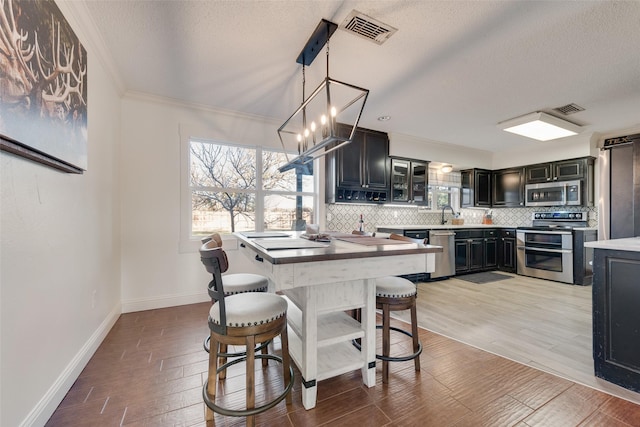 dining room featuring sink, ornamental molding, a chandelier, and a textured ceiling