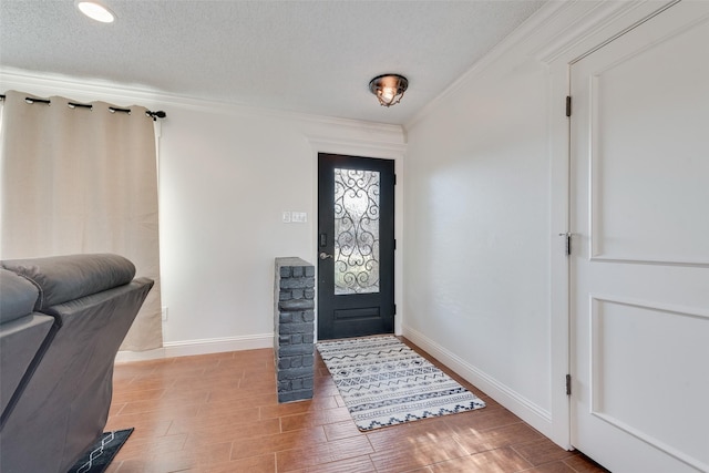 entrance foyer with ornamental molding and a textured ceiling