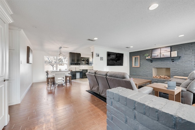 living room featuring a textured ceiling, a fireplace, and light hardwood / wood-style floors