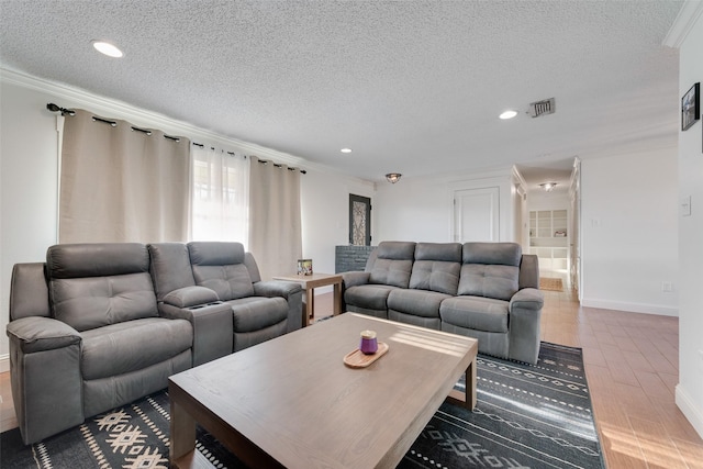 living room with hardwood / wood-style flooring, ornamental molding, and a textured ceiling