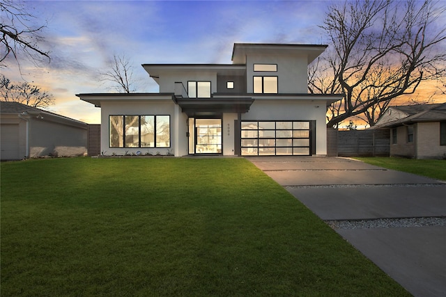 contemporary home featuring a garage and a lawn