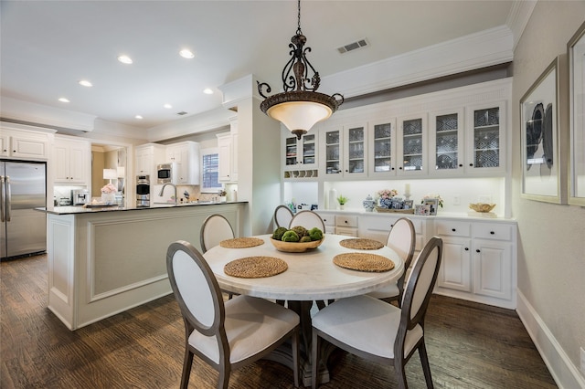 dining area featuring crown molding and dark wood-type flooring