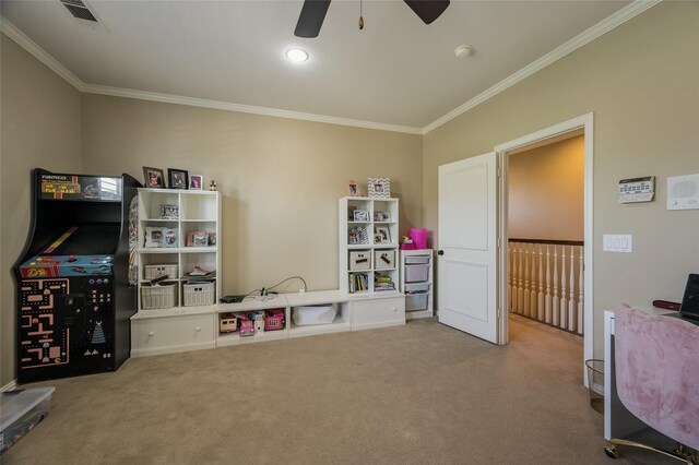 rec room with crown molding, carpet flooring, and ceiling fan