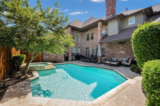 view of pool with an in ground hot tub and a patio