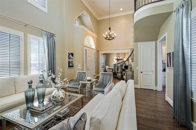 living room featuring a high ceiling, ornamental molding, dark hardwood / wood-style floors, and a notable chandelier