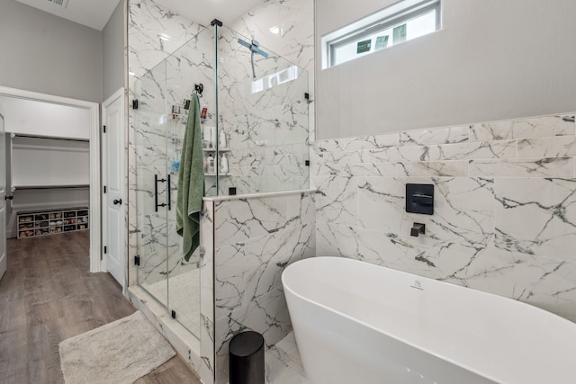 bathroom featuring separate shower and tub, hardwood / wood-style floors, and tile walls