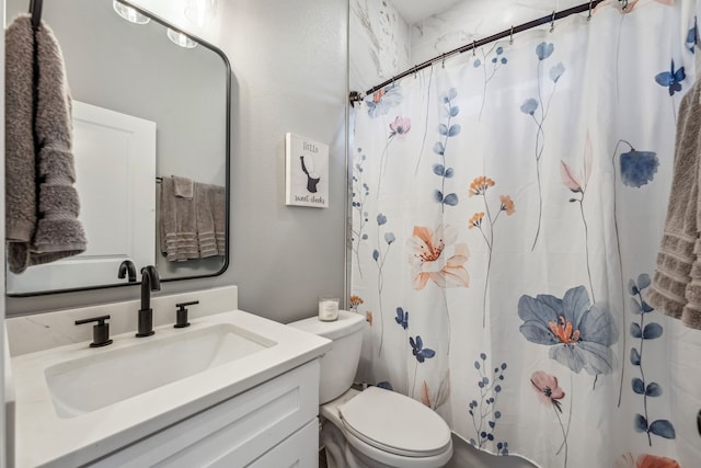 bathroom featuring vanity, walk in shower, and toilet