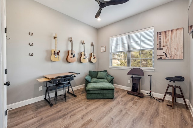 living area with hardwood / wood-style flooring and ceiling fan