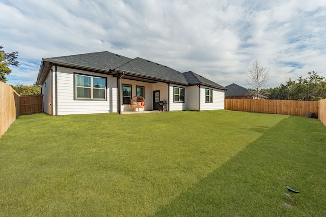 rear view of house with a yard and a patio area