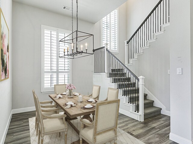 dining room with stairway, an inviting chandelier, wood finished floors, and visible vents