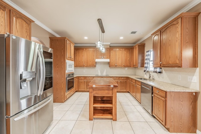 kitchen featuring light tile patterned flooring, appliances with stainless steel finishes, decorative light fixtures, sink, and a center island