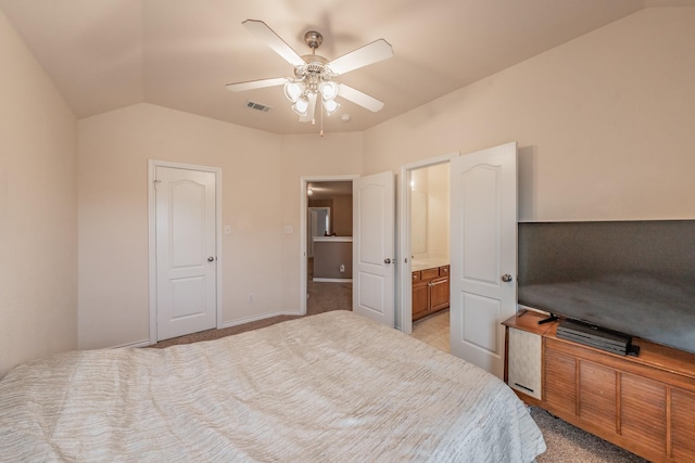 bedroom featuring ceiling fan, connected bathroom, and vaulted ceiling