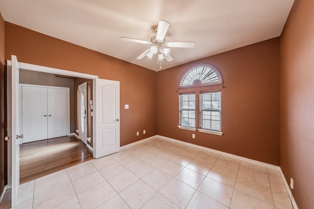 spare room with ceiling fan and light tile patterned floors