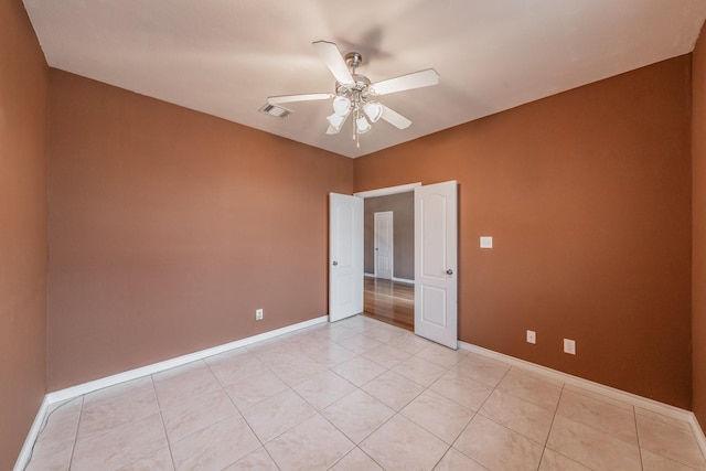 tiled spare room featuring ceiling fan