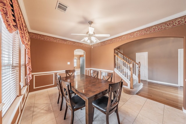 tiled dining area featuring ornamental molding, a healthy amount of sunlight, and ceiling fan