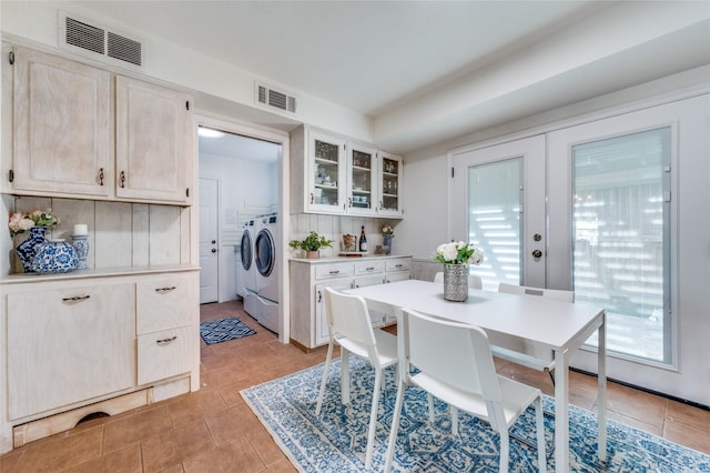 tiled dining space with washer and dryer and french doors