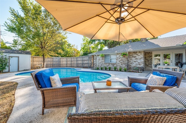 view of pool with french doors, a storage unit, outdoor lounge area, and a patio