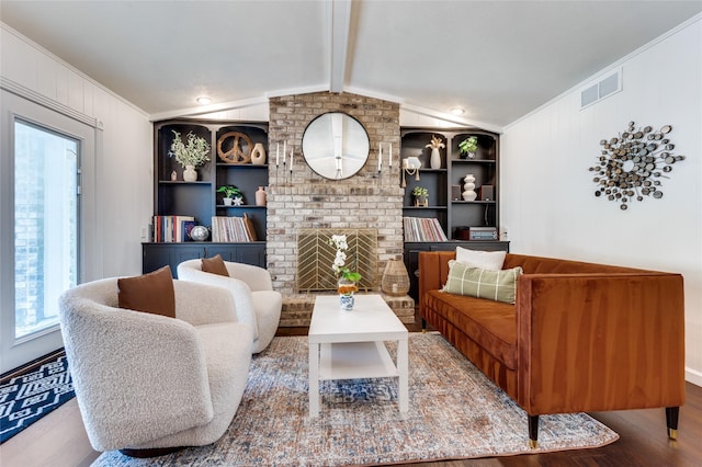 living room with built in features, a fireplace, ornamental molding, lofted ceiling with beams, and light hardwood / wood-style floors