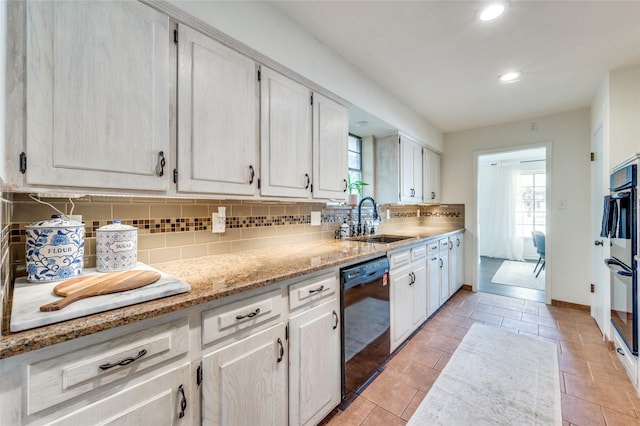 kitchen with white cabinetry, sink, decorative backsplash, and black appliances