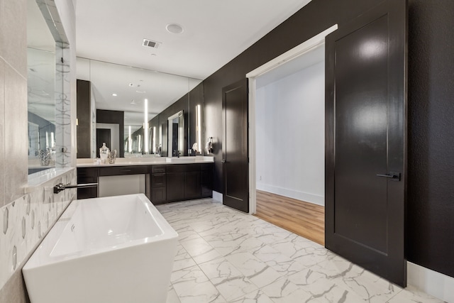 bathroom featuring vanity and a tub to relax in