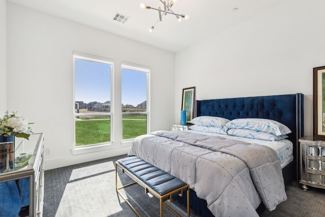 bedroom with an inviting chandelier and dark colored carpet