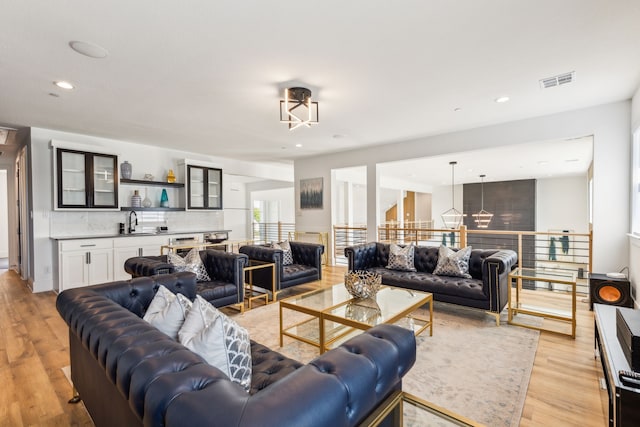 living room with sink and light hardwood / wood-style floors