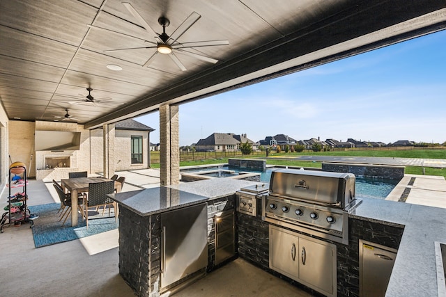 view of patio with area for grilling, an outdoor bar, and ceiling fan