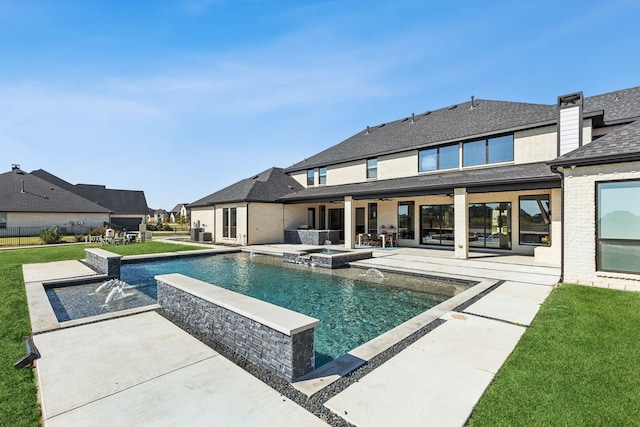 view of pool featuring an in ground hot tub, a lawn, and a patio