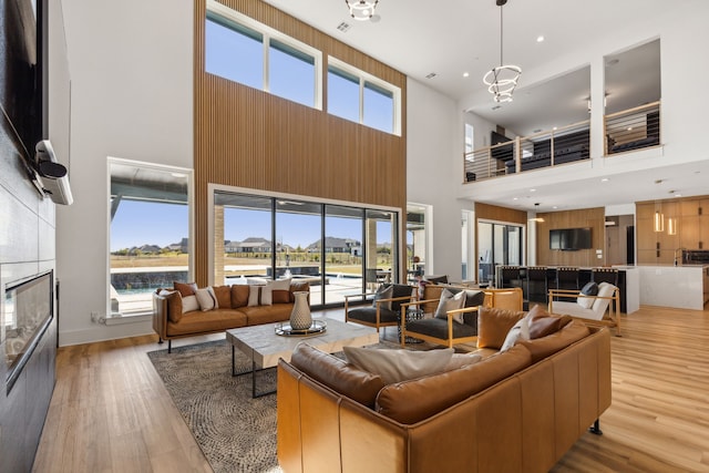 living room with a healthy amount of sunlight, an inviting chandelier, and light hardwood / wood-style floors