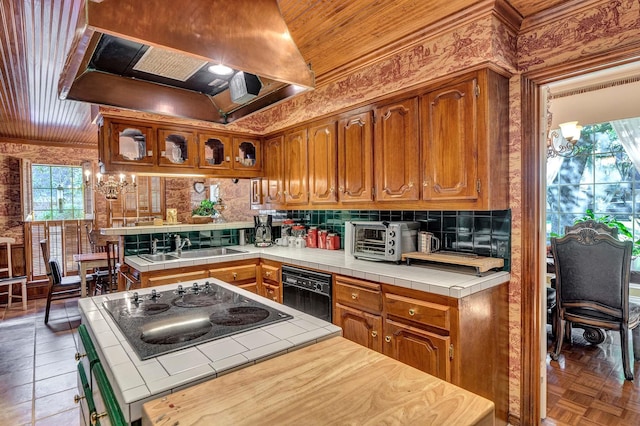 kitchen featuring brown cabinets, tile counters, glass insert cabinets, premium range hood, and dishwasher