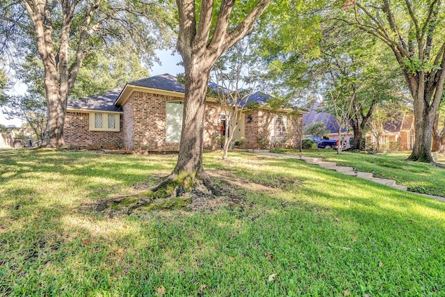 ranch-style home featuring a front yard and brick siding