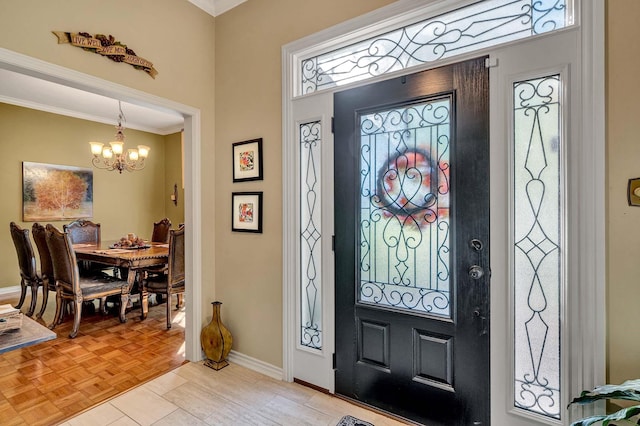 entryway featuring ornamental molding, a chandelier, and light parquet floors