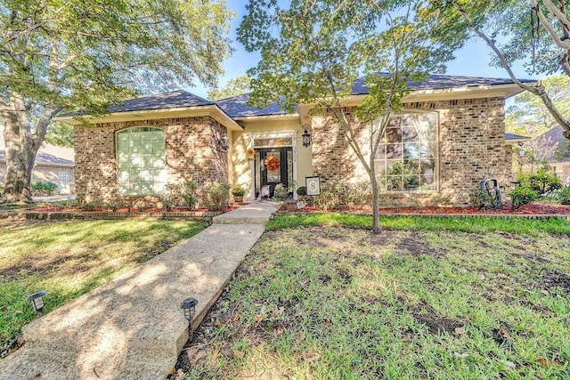 view of front of home featuring a front lawn and brick siding