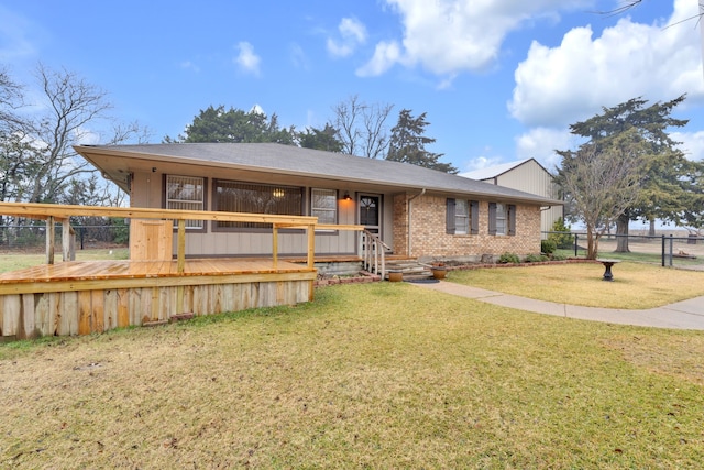 ranch-style house with a wooden deck and a front yard