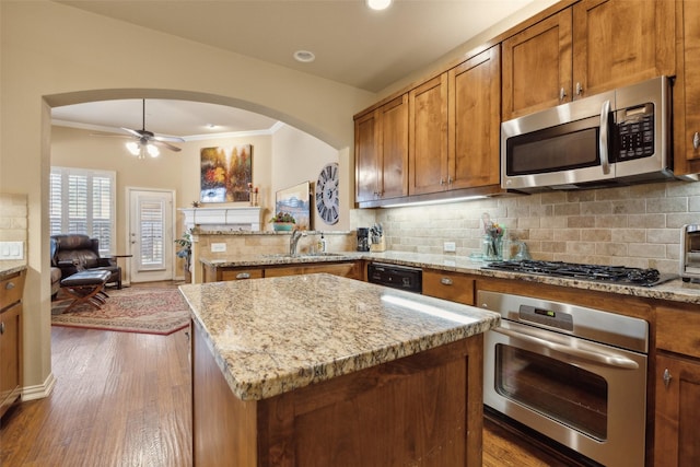 kitchen with appliances with stainless steel finishes, a center island, sink, and kitchen peninsula