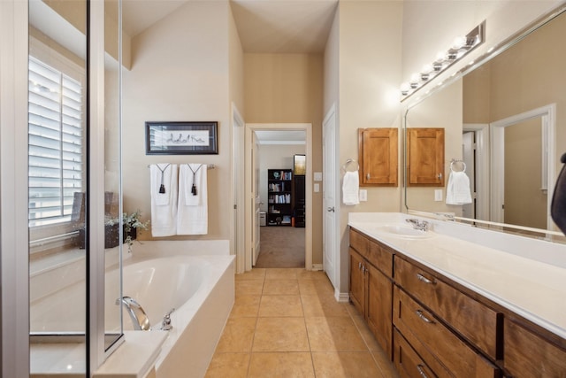 bathroom featuring tile patterned flooring, vanity, and a tub to relax in