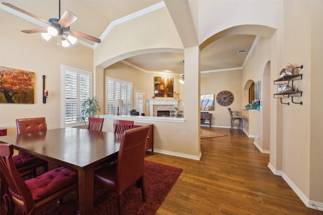 dining area featuring hardwood / wood-style flooring, crown molding, ceiling fan, and high vaulted ceiling