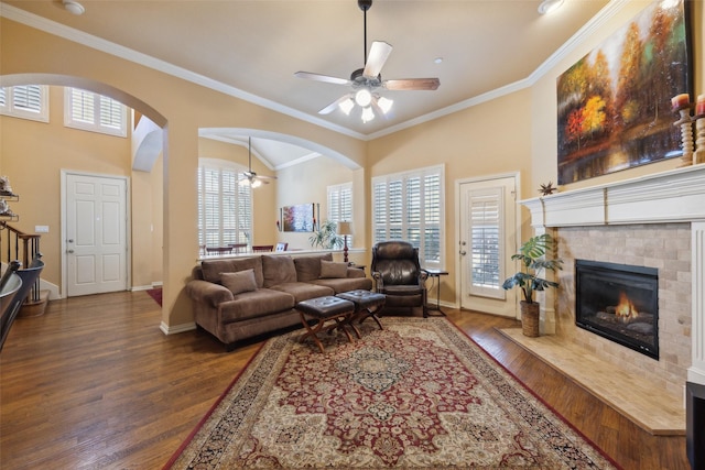 living room with ceiling fan, ornamental molding, dark hardwood / wood-style floors, and a fireplace