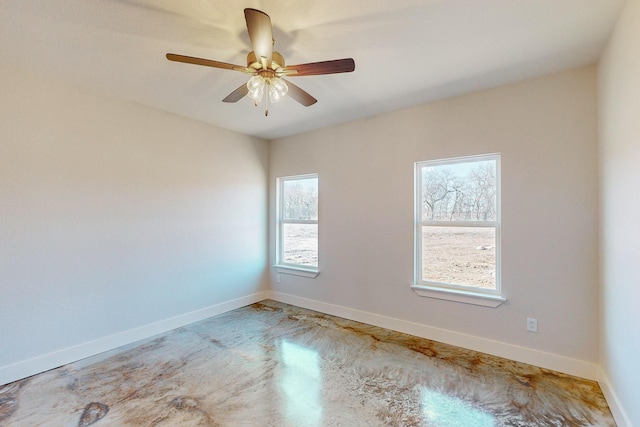 spare room featuring ceiling fan and concrete floors