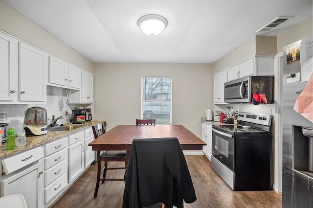 kitchen featuring light stone countertops, white cabinetry, and appliances with stainless steel finishes