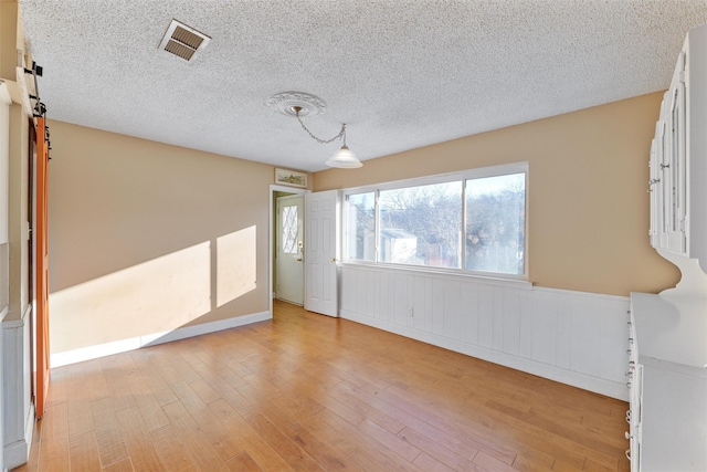 empty room featuring light hardwood / wood-style flooring and a textured ceiling