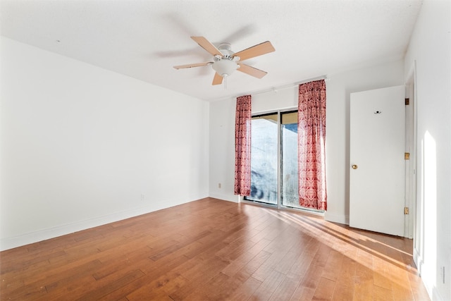 empty room with hardwood / wood-style flooring and ceiling fan